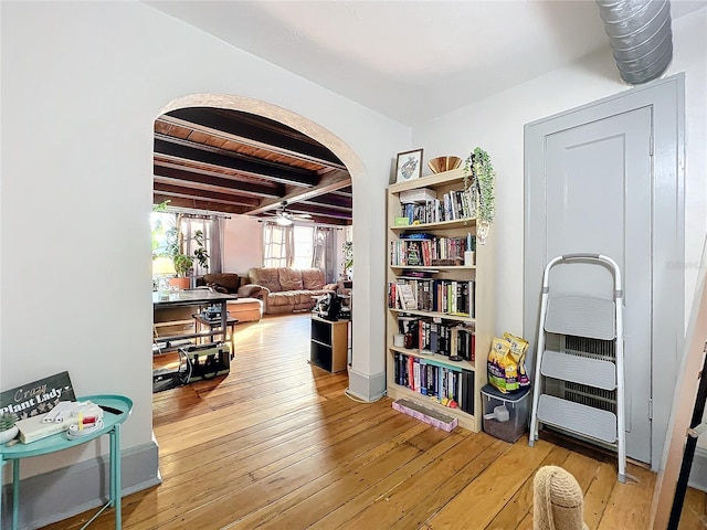 sitting room featuring ceiling fan, light hardwood / wood-style flooring, and beamed ceiling