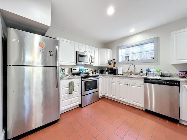 kitchen featuring sink, white cabinetry, stainless steel appliances, and light tile patterned floors