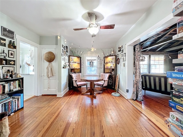 sitting room with ceiling fan and wood-type flooring