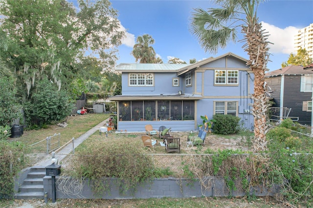 rear view of property featuring a sunroom