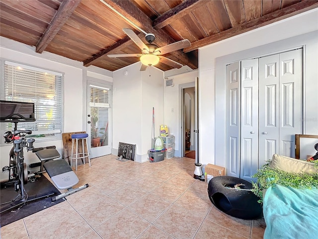 workout area with ceiling fan, light tile patterned floors, and wood ceiling