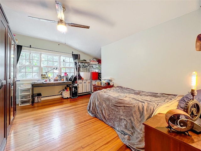 bedroom featuring light hardwood / wood-style flooring, vaulted ceiling, and ceiling fan