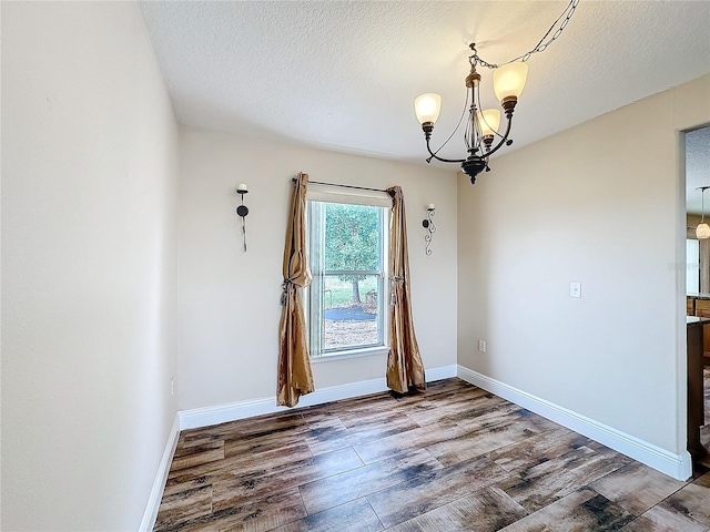 interior space featuring hardwood / wood-style flooring, a textured ceiling, and an inviting chandelier