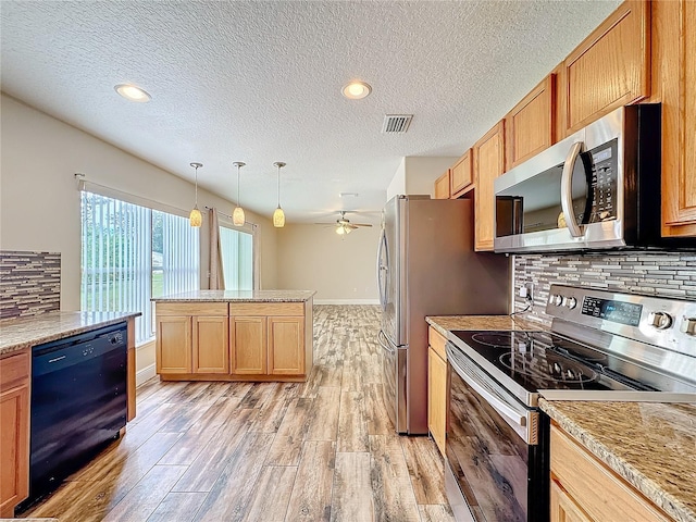 kitchen with backsplash, ceiling fan, pendant lighting, and stainless steel appliances