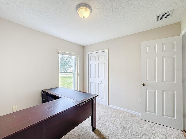 office with a textured ceiling and light carpet