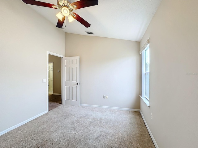 carpeted spare room with ceiling fan and lofted ceiling