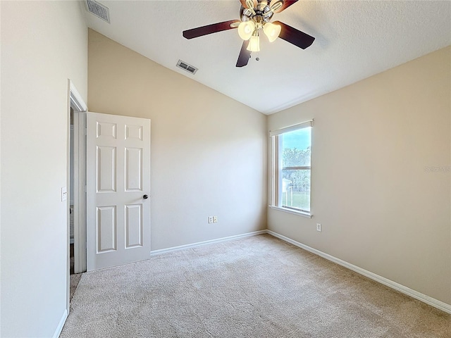 empty room with ceiling fan, light carpet, and vaulted ceiling