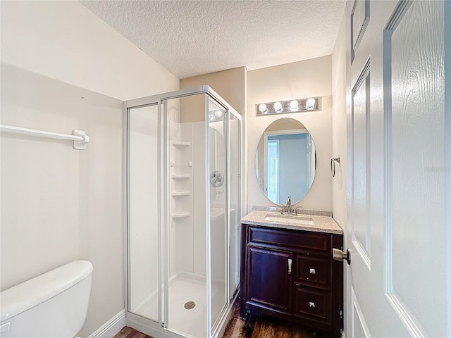 bathroom featuring toilet, an enclosed shower, a textured ceiling, and vanity