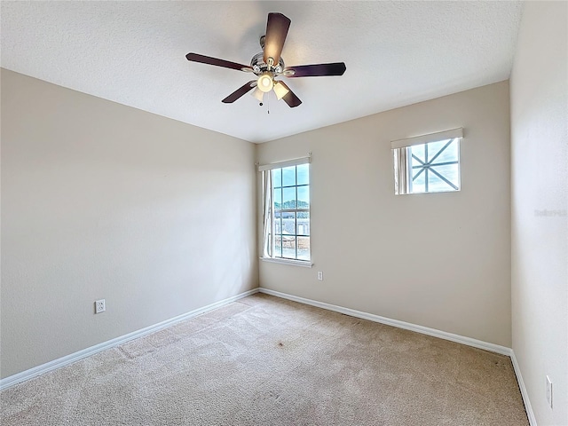 carpeted empty room with ceiling fan and a textured ceiling