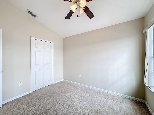 unfurnished bedroom featuring carpet flooring, ceiling fan, a closet, and lofted ceiling