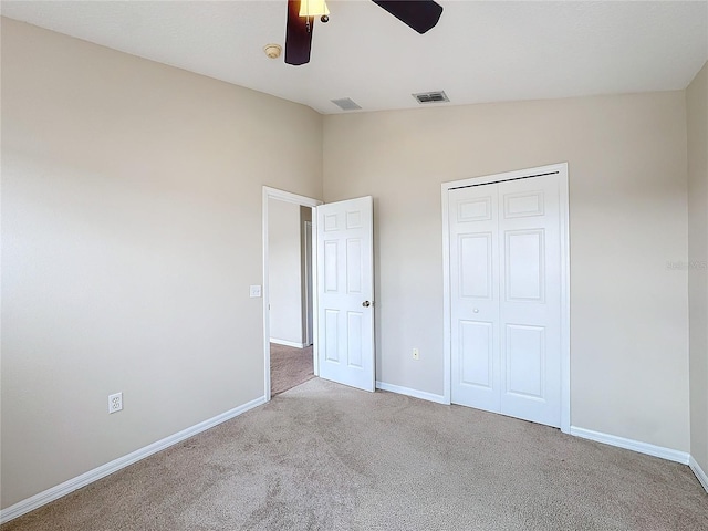 unfurnished bedroom with ceiling fan, lofted ceiling, light carpet, and a closet