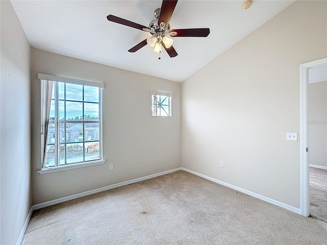 spare room with ceiling fan, light colored carpet, and lofted ceiling