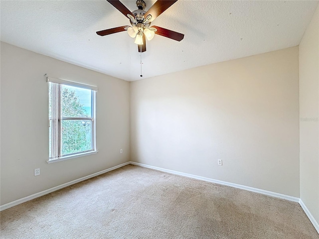 spare room featuring ceiling fan, carpet floors, and a textured ceiling