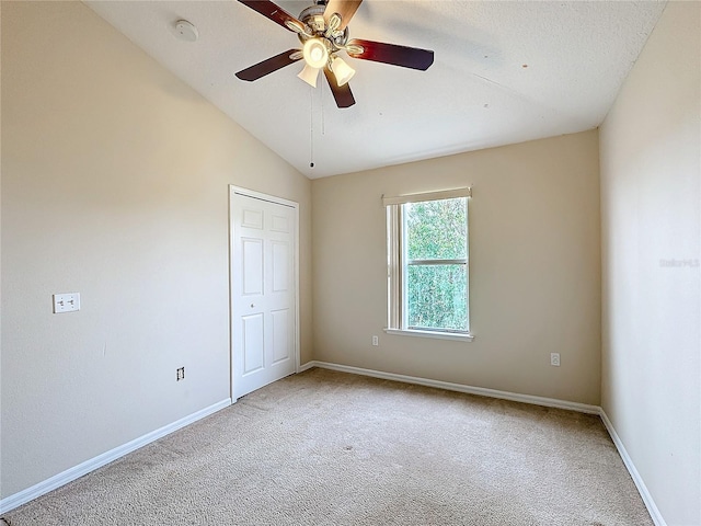 unfurnished bedroom featuring ceiling fan, carpet floors, and vaulted ceiling