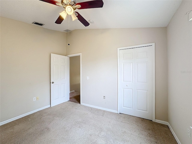 unfurnished bedroom with ceiling fan, light colored carpet, lofted ceiling, and a closet