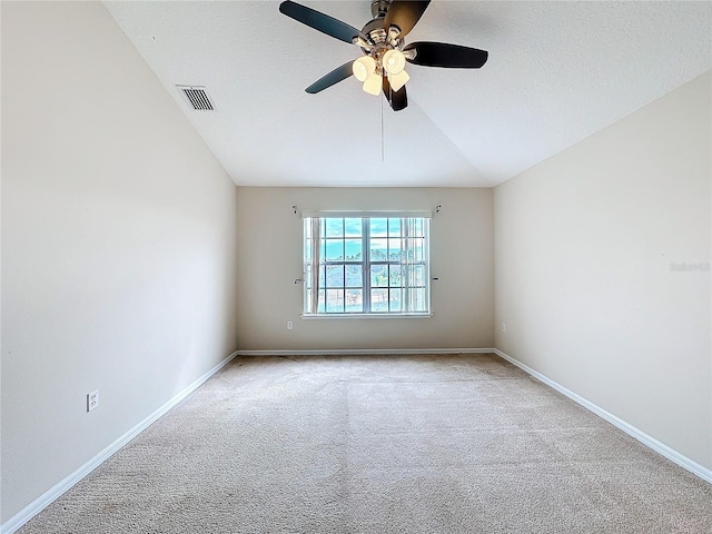 carpeted spare room featuring ceiling fan, lofted ceiling, and a textured ceiling