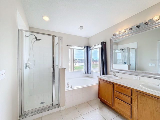 bathroom with tile patterned flooring, vanity, a textured ceiling, and plus walk in shower