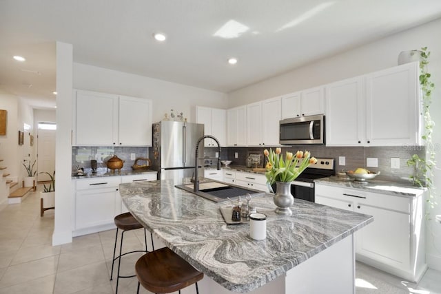 kitchen with white cabinetry, a kitchen island with sink, and appliances with stainless steel finishes