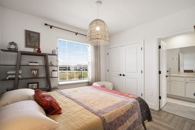 bedroom with ensuite bath and light parquet floors