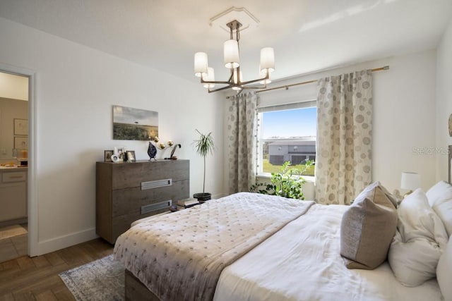 bedroom featuring an inviting chandelier, parquet floors, and ensuite bath