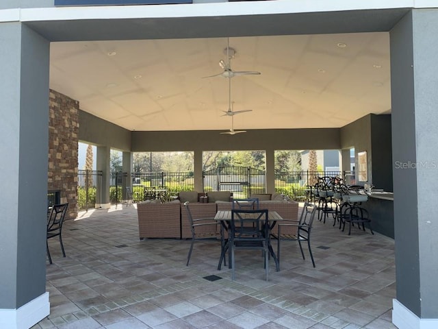 view of patio with ceiling fan and an outdoor stone fireplace