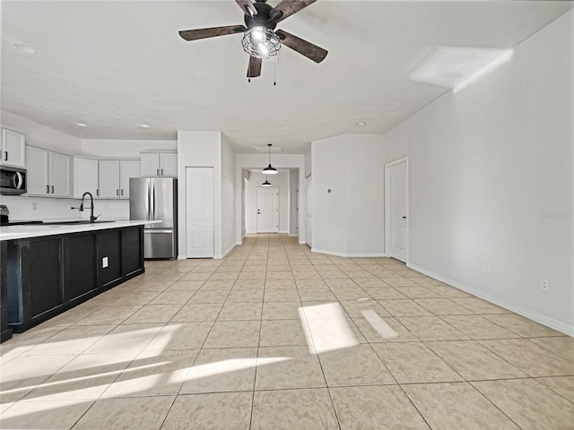 kitchen featuring stainless steel appliances, ceiling fan, sink, white cabinetry, and light tile patterned flooring