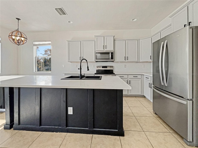3105 46th St E, Palmetto, FL 34221 - kitchen with appliances with stainless steel finishes, light countertops, a center island with sink, light tile patterned flooring, and white cabinets