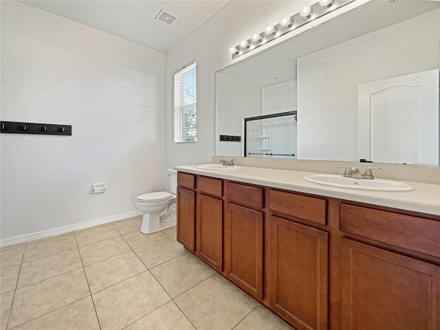 bathroom featuring tile patterned floors, vanity, toilet, and a shower with door