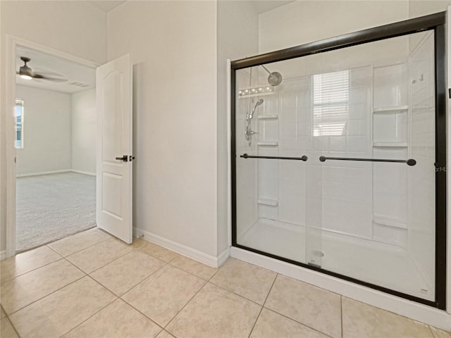 bathroom with tile patterned floors, ceiling fan, and a shower with shower door