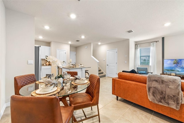 dining room featuring light tile patterned floors and a textured ceiling