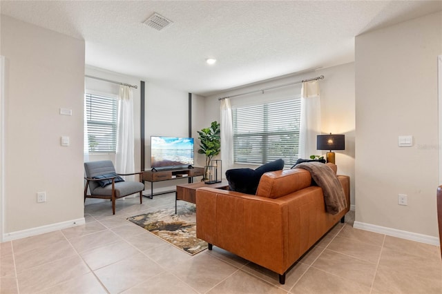 living room featuring plenty of natural light, light tile patterned floors, and a textured ceiling