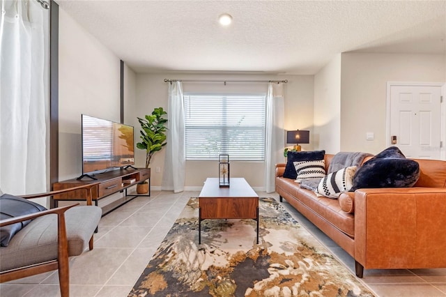 living room with a textured ceiling and light tile patterned flooring