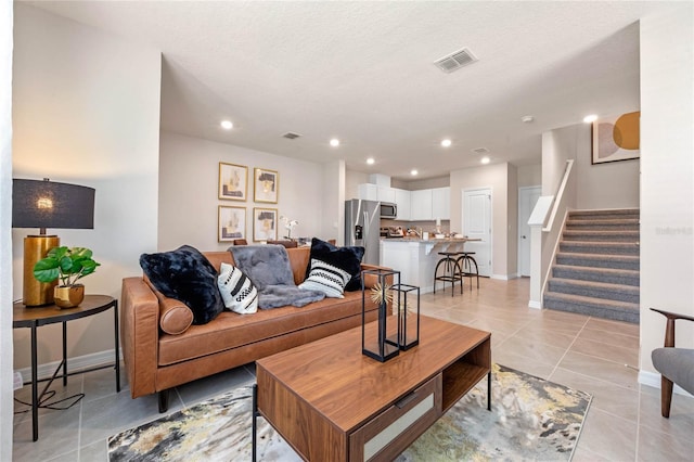 tiled living room featuring a textured ceiling