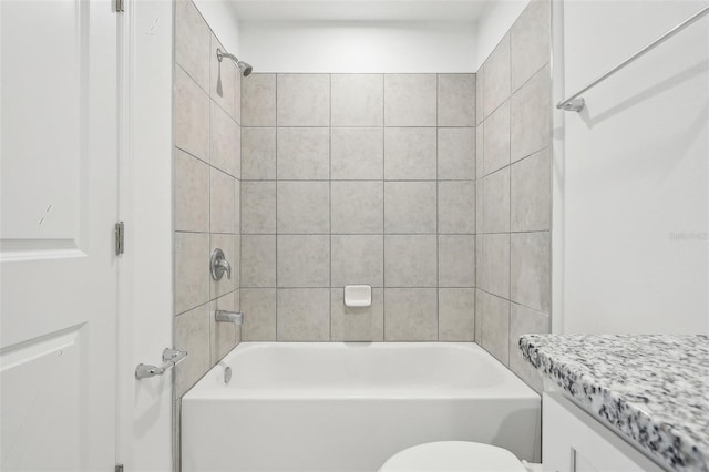 full bathroom with toilet, vanity, and tiled shower / bath