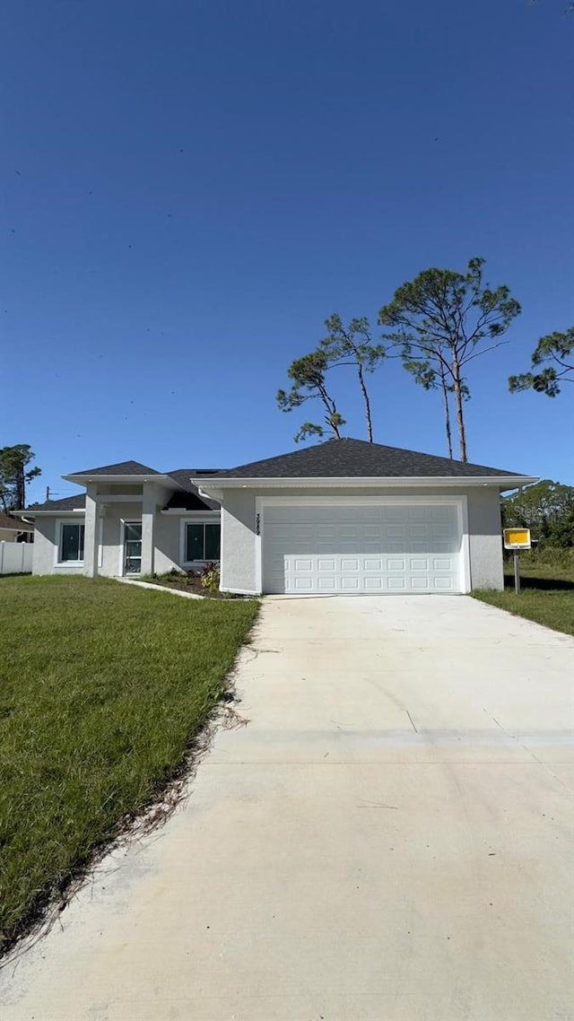 view of front of property with a front lawn and a garage