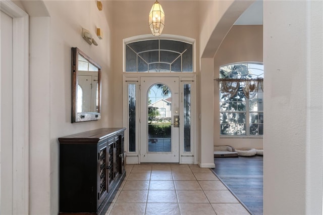 tiled foyer with a chandelier and a high ceiling