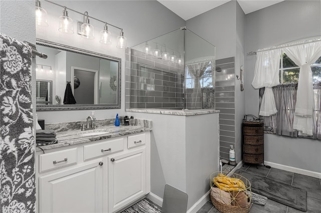 bathroom featuring a tile shower, tile patterned floors, and vanity