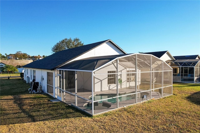 back of house with a patio, a yard, and glass enclosure