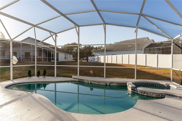 view of swimming pool with glass enclosure, a yard, and an in ground hot tub