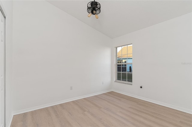 unfurnished room with light wood-type flooring and vaulted ceiling