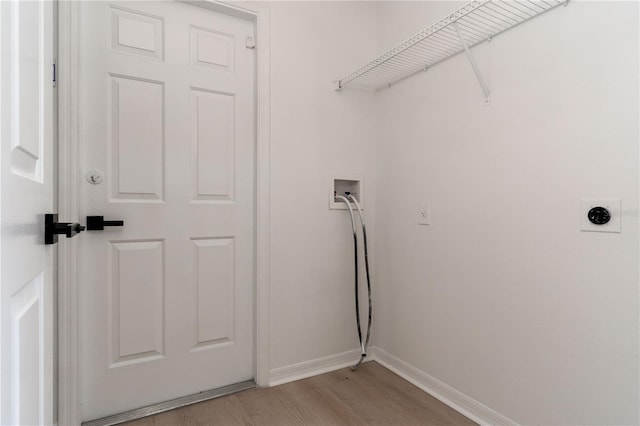 clothes washing area with electric dryer hookup, washer hookup, and light hardwood / wood-style floors