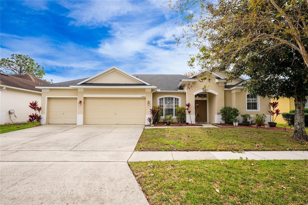 single story home with a garage and a front yard