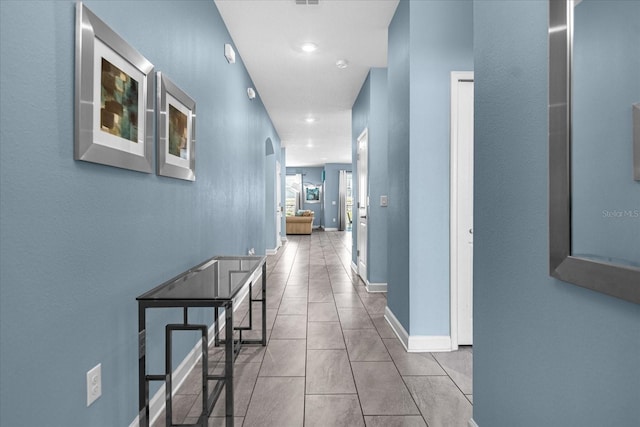 hall featuring light tile patterned floors