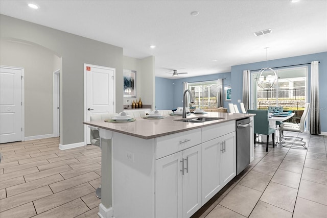 kitchen featuring ceiling fan with notable chandelier, sink, an island with sink, decorative light fixtures, and white cabinetry