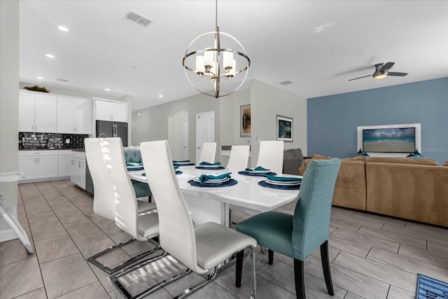 dining area featuring ceiling fan with notable chandelier