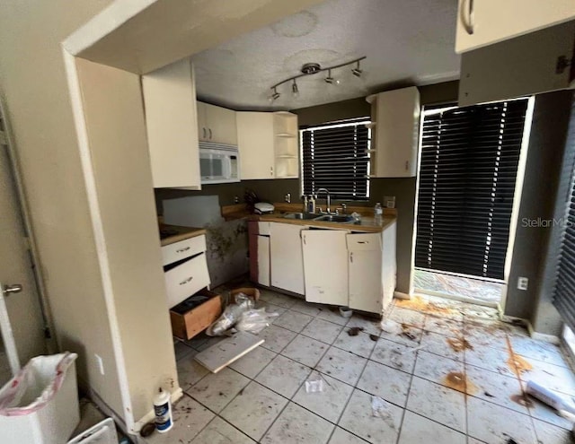 kitchen featuring sink, white cabinets, and rail lighting