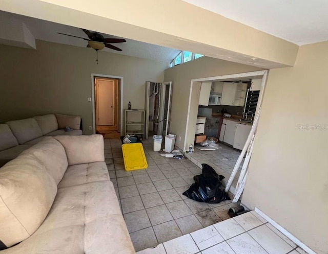 tiled living room with ceiling fan and sink