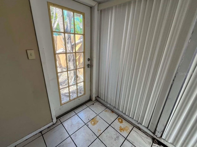 doorway to outside with light tile patterned flooring