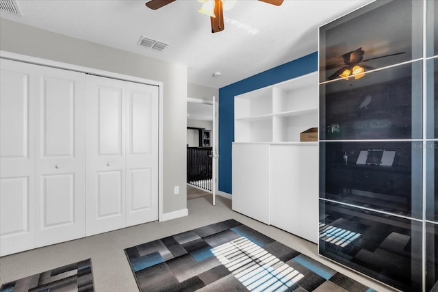 interior space with carpet flooring, ceiling fan, and a closet