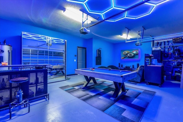 rec room with electric water heater, a textured ceiling, and billiards